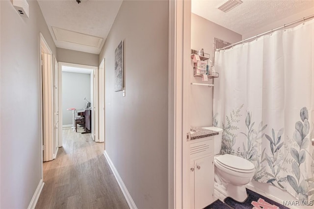 bathroom featuring hardwood / wood-style flooring, vanity, toilet, a textured ceiling, and a shower with curtain