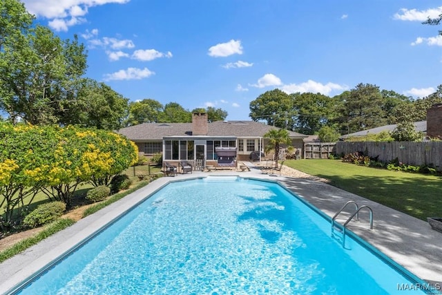 view of pool with a yard, a patio, and a sunroom