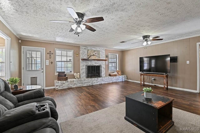 living room featuring dark hardwood / wood-style flooring, a wealth of natural light, and ornamental molding