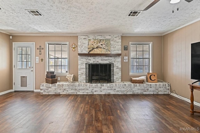 unfurnished living room with a brick fireplace, crown molding, dark hardwood / wood-style floors, and ceiling fan