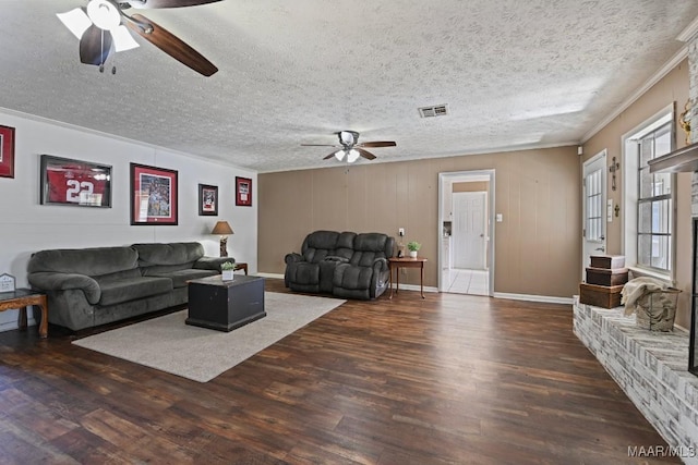 living room with crown molding, ceiling fan, dark hardwood / wood-style flooring, and a textured ceiling