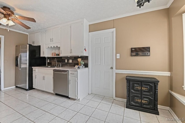 kitchen featuring sink, white cabinetry, crown molding, light tile patterned floors, and appliances with stainless steel finishes