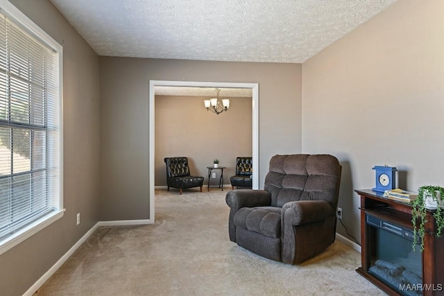 living area with light carpet, a textured ceiling, and a chandelier