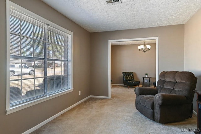 sitting room featuring an inviting chandelier, light colored carpet, plenty of natural light, and a textured ceiling