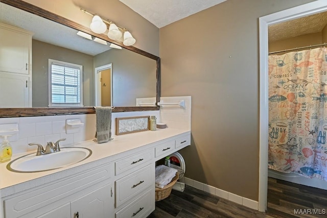 bathroom featuring tasteful backsplash, wood-type flooring, a textured ceiling, vanity, and curtained shower