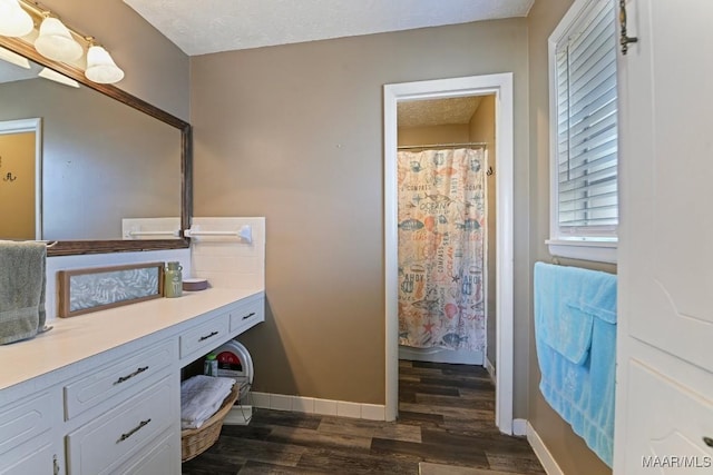 bathroom featuring vanity, hardwood / wood-style flooring, curtained shower, and a textured ceiling