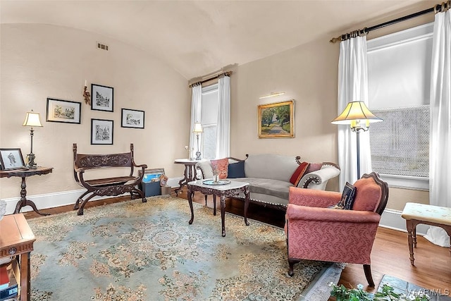 living area with vaulted ceiling and hardwood / wood-style floors