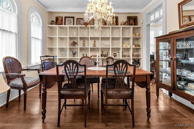 dining area featuring ornamental molding, hardwood / wood-style floors, and a notable chandelier