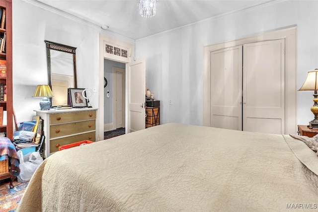 bedroom featuring an inviting chandelier, ornamental molding, and a closet