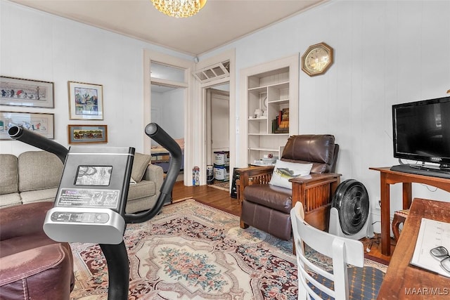 interior space featuring hardwood / wood-style flooring, an inviting chandelier, and built in shelves