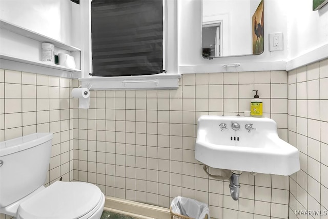 bathroom with tile walls, sink, and toilet