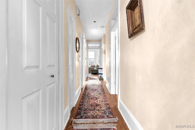 hallway with hardwood / wood-style flooring