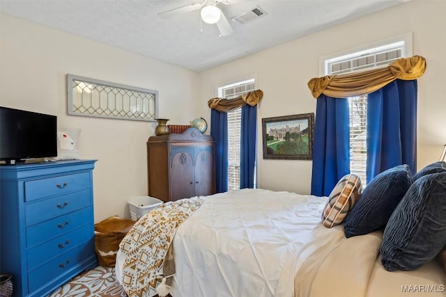 bedroom featuring ceiling fan and a textured ceiling