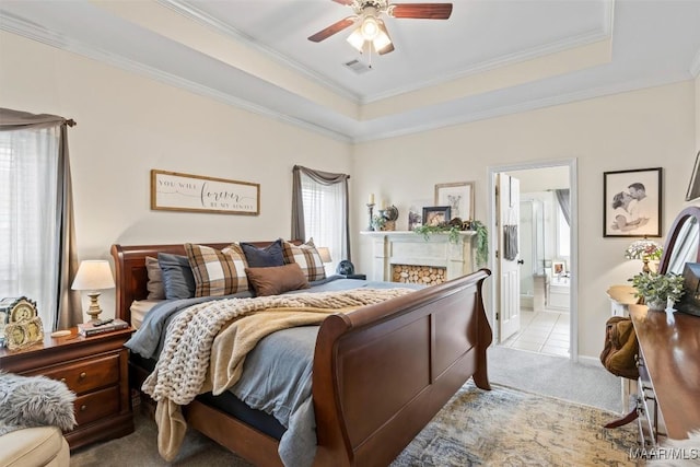 bedroom with crown molding, a tray ceiling, and light colored carpet