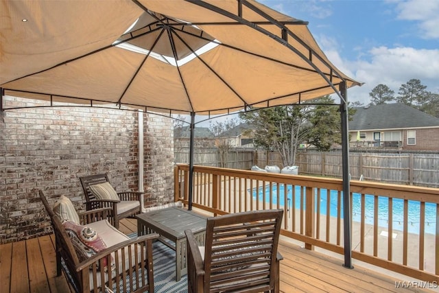 deck with a fenced in pool, a gazebo, a water view, and a beach view