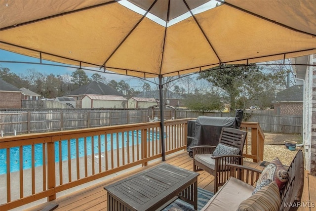 wooden deck featuring a fenced in pool, a gazebo, and a view of the beach