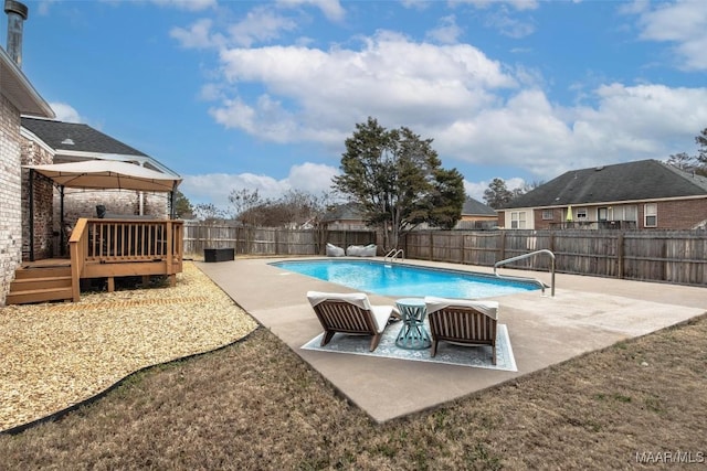 view of swimming pool with a wooden deck and a patio