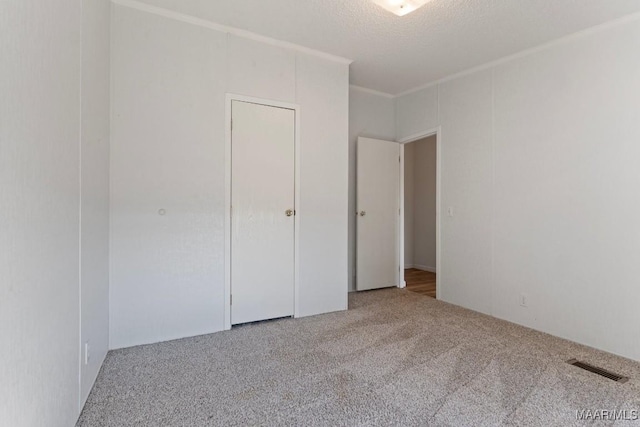 unfurnished bedroom featuring crown molding, carpet floors, and a textured ceiling