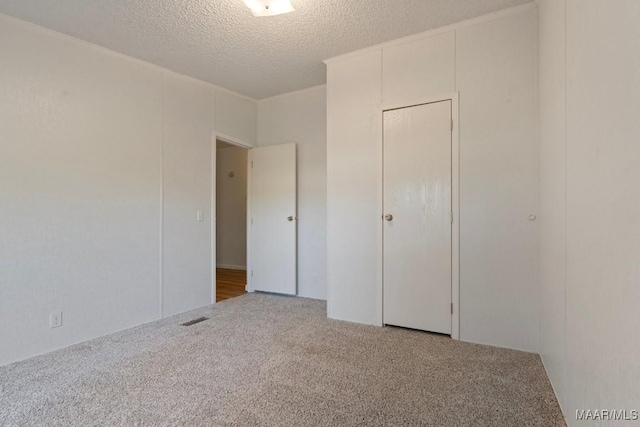 unfurnished bedroom with carpet floors and a textured ceiling