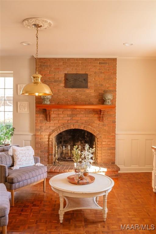 living area featuring parquet floors, ornamental molding, and a fireplace