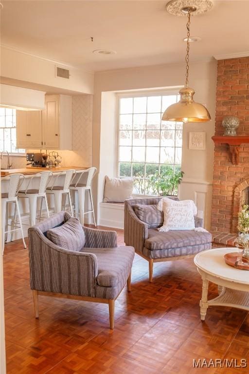 living room with parquet flooring, a healthy amount of sunlight, a fireplace, and sink