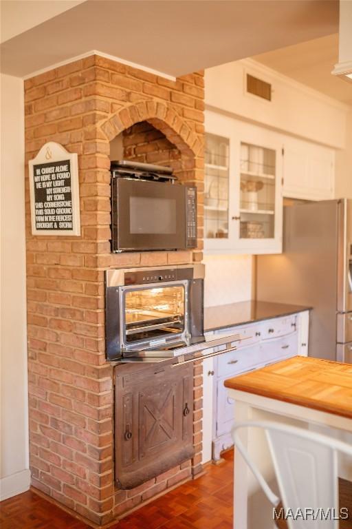 kitchen with white cabinetry, appliances with stainless steel finishes, and wooden counters