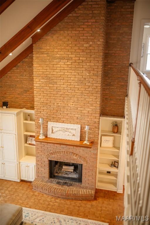 unfurnished living room featuring high vaulted ceiling and a fireplace