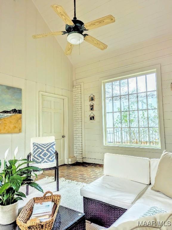 living room featuring ceiling fan and lofted ceiling