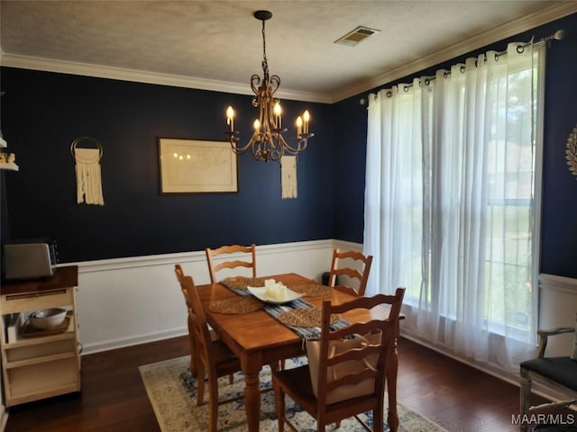 dining space with crown molding, an inviting chandelier, and dark wood-type flooring