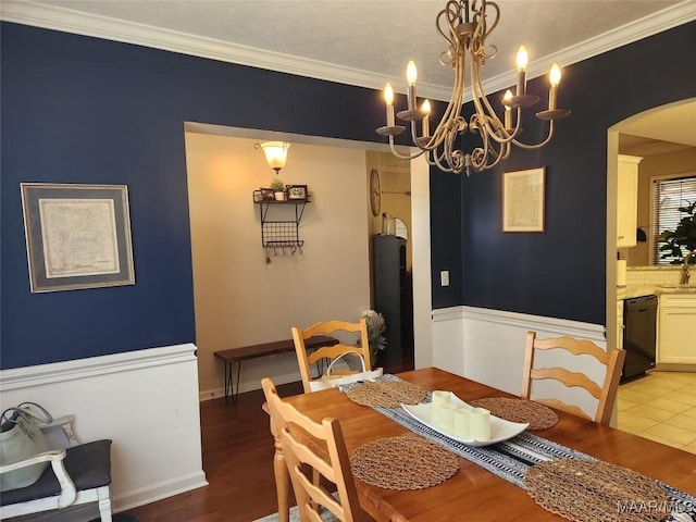 dining space with ornamental molding, wood-type flooring, and sink