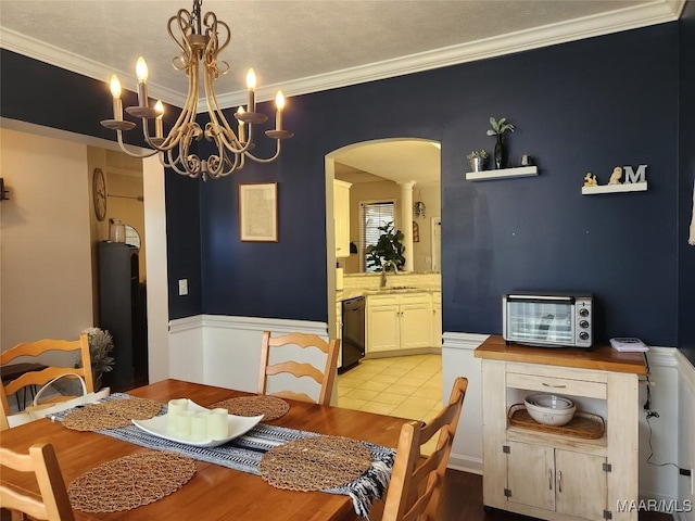 dining room with ornamental molding, sink, and light hardwood / wood-style flooring