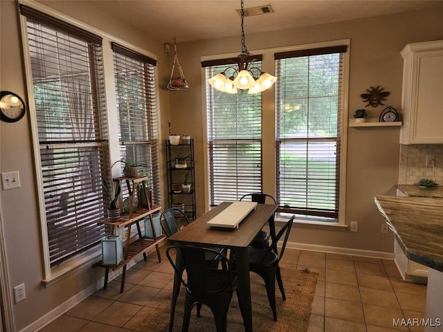 tiled dining room with a notable chandelier