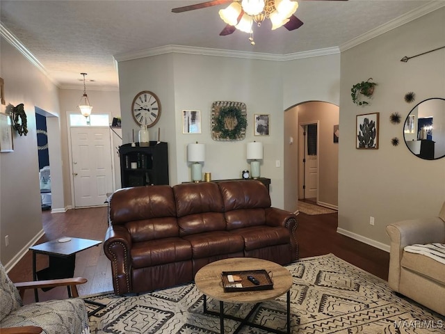 living room with crown molding, dark hardwood / wood-style floors, and ceiling fan