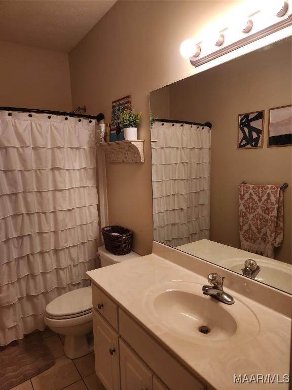 bathroom with tile patterned flooring, vanity, and toilet