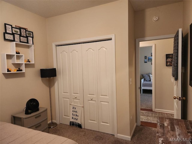 bedroom with a closet and dark colored carpet