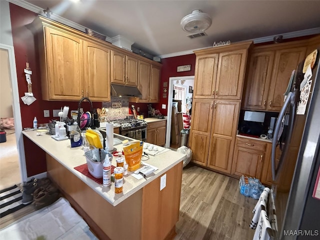 kitchen featuring a breakfast bar area, crown molding, light wood-type flooring, appliances with stainless steel finishes, and kitchen peninsula