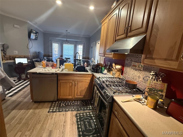 kitchen featuring sink, hanging light fixtures, stainless steel range with gas cooktop, black dishwasher, and hardwood / wood-style flooring