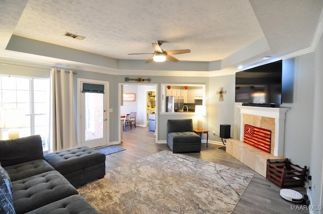 living room featuring hardwood / wood-style flooring, a raised ceiling, and a textured ceiling