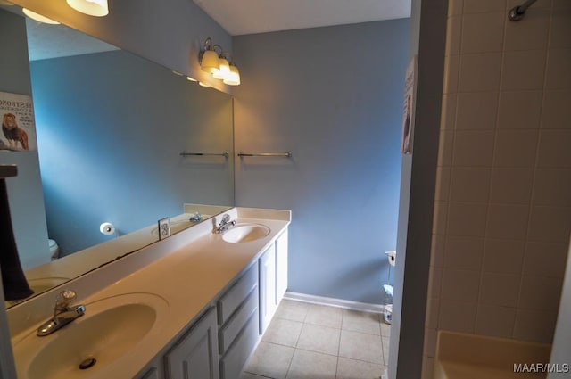 bathroom featuring tiled shower, vanity, and tile patterned flooring