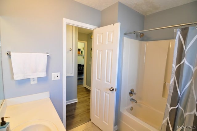 bathroom featuring vanity, a textured ceiling, shower / tub combo, and tile patterned floors