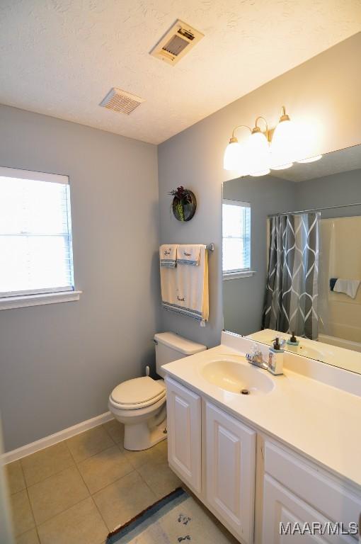 bathroom featuring vanity, toilet, and tile patterned flooring