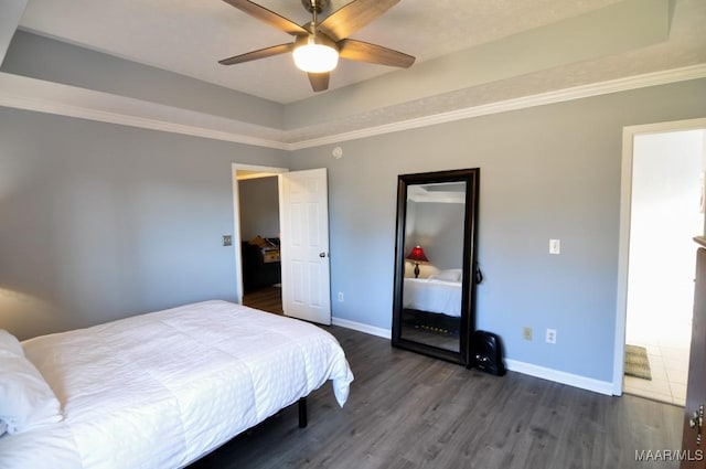 bedroom featuring a raised ceiling, crown molding, ceiling fan, and dark hardwood / wood-style flooring