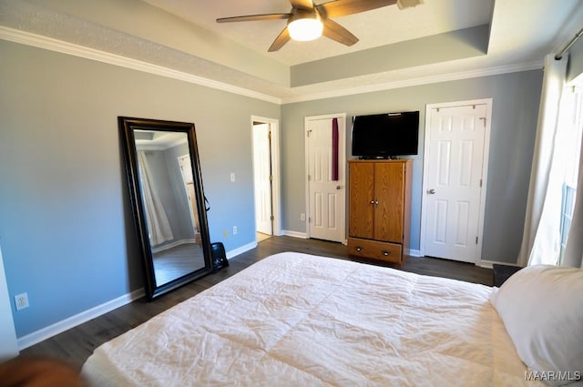 bedroom with ceiling fan, ornamental molding, dark hardwood / wood-style flooring, and a raised ceiling