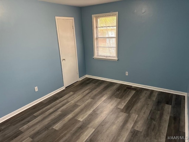 spare room with dark wood-type flooring