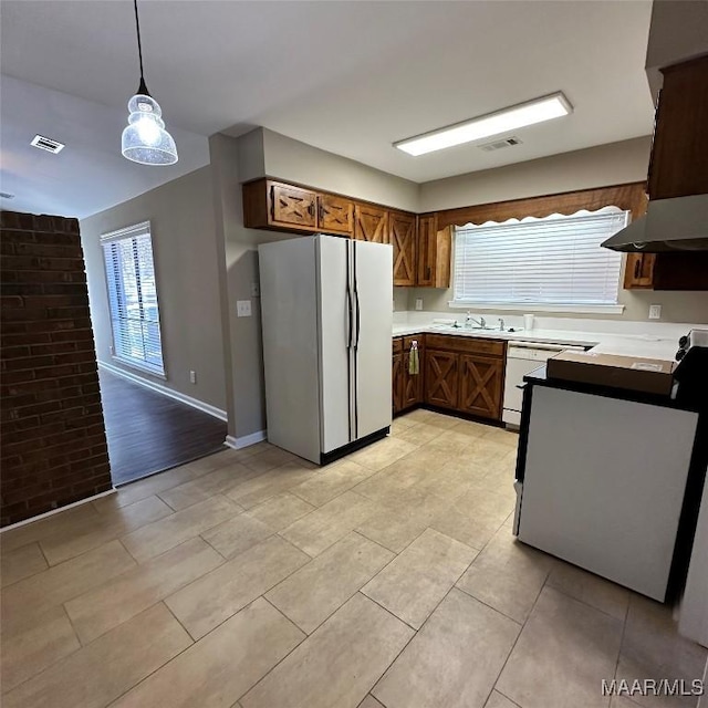 kitchen featuring sink, white appliances, hanging light fixtures, ventilation hood, and light tile patterned flooring