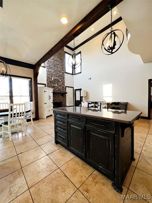 kitchen featuring pendant lighting, a breakfast bar, a chandelier, and beamed ceiling