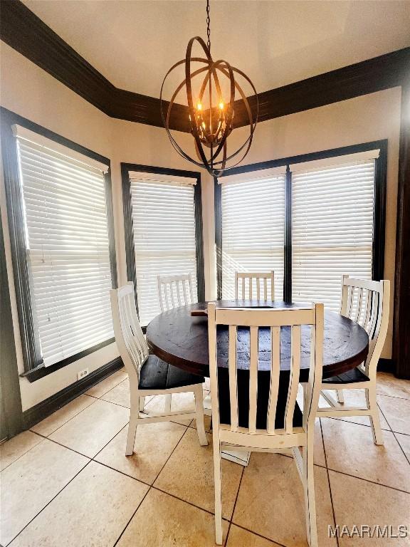 tiled dining room featuring ornamental molding, plenty of natural light, and an inviting chandelier