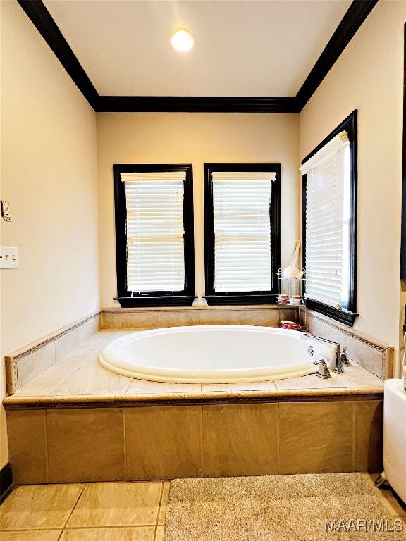 bathroom featuring a relaxing tiled tub and crown molding