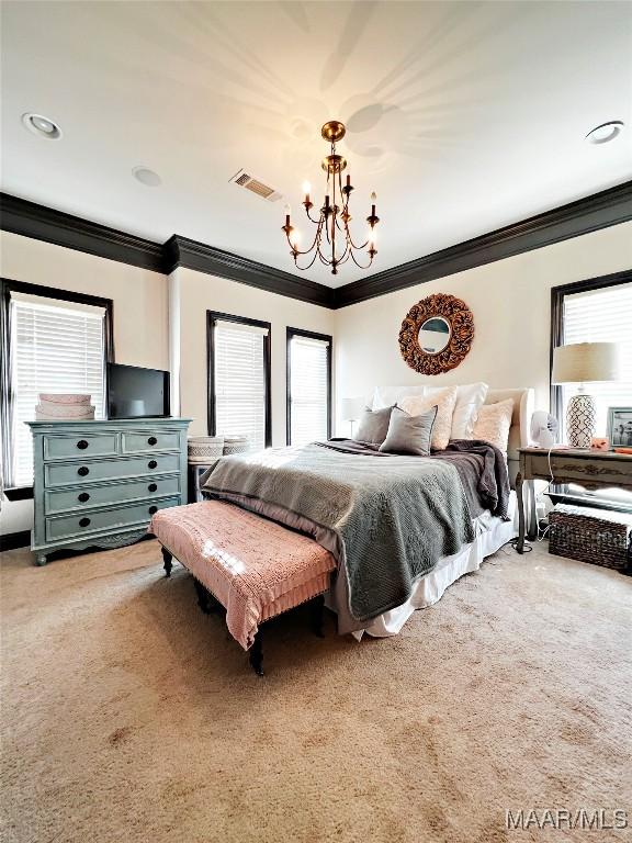 bedroom with crown molding, carpet floors, and a chandelier