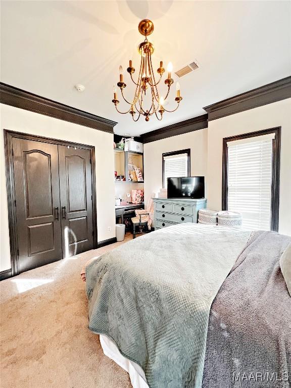 carpeted bedroom with ornamental molding and a chandelier